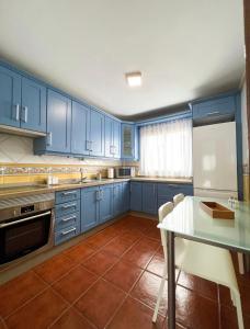 莫卡诺尔La casa de Tenesedra的厨房配有蓝色橱柜、桌子和冰箱。