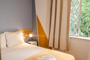 圣保罗Lamparina Hostel的一间卧室设有一张床和一个窗口