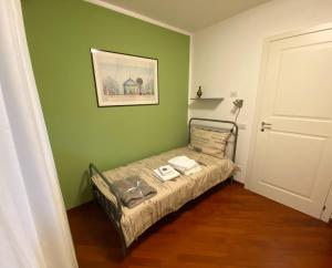 博尔扎诺Living Rencio: vicino al Centro di Bolzano的一间小卧室,在绿色的墙上配有一张床