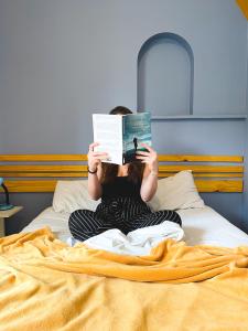 圣保罗Lamparina Hostel的坐在床上读书的女人