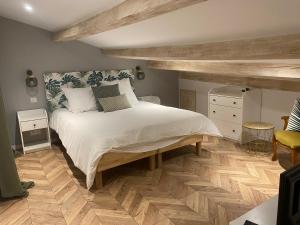 卡斯特拉讷Maison St Victor的一间卧室设有一张大床,铺有木地板