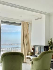 罗萨斯Luxury family apartment in Roses的客厅设有绿椅和窗户