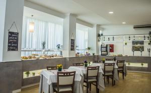 里米尼桑德拉酒店的一间带桌椅的用餐室和一间面包店