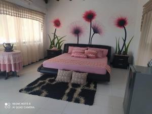 CaucasiaCasa Campo Emaus的一间卧室配有粉红色的床、粉红色枕头和鲜花