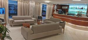 里米尼桑德拉酒店的一间设有两张沙发的等候室和一间酒吧