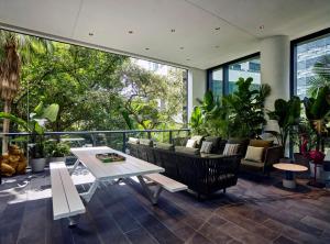 迈阿密citizenM Miami Brickell的一个带沙发和桌子的庭院,以及一些植物