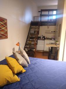 耶尔瓦布埃纳Azules de Abril的一间卧室配有带枕头的床和楼梯。