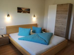涅德劳Moarhof Appartements的一间卧室配有一张带蓝色枕头的床