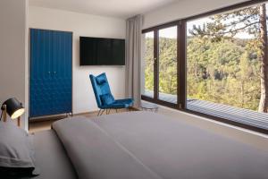 HradišťkoVila Hradištko的一间卧室配有一张床、一张蓝色椅子和窗户。