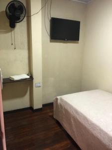 阿拉胡埃拉#2 private room close to airport的卧室配有一张床,墙上配有电视。