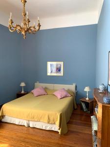 科莫B&B Volta的卧室拥有蓝色的墙壁,配有一张带粉红色枕头的床。