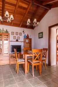 BenchijiguaCasa Rural La Palizada的一间带木桌和椅子的用餐室