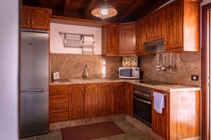 BenchijiguaCasa Rural La Palizada的厨房配有木制橱柜和不锈钢冰箱。