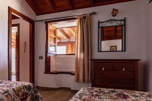 BenchijiguaCasa Rural La Palizada的一间卧室配有梳妆台、镜子和窗户。
