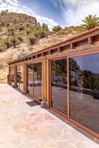 BenchijiguaCasa Rural La Palizada的庭院上设有玻璃门的房子