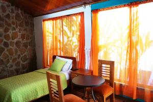 阿约拉港Isla Azul的一间卧室配有一张床、一张桌子和一个窗户。