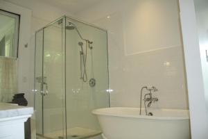 萨拉纳克莱克Franklin Manor Bed and Breakfast的浴室设有玻璃淋浴间、浴缸和水槽