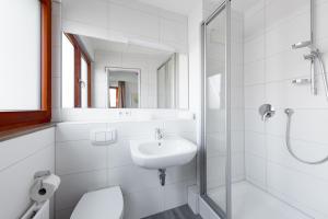 斯图加特Hotel Garni am Olgaeck的白色的浴室设有水槽和淋浴。