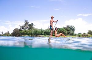 希洛Stunning Views Best location in Hilo 2BR modern Condo的水中一个男女的桨板