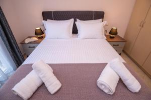 Ágios RókkosZoes Luxury Apartment Corfu的一间卧室配有一张床,上面有两条毛巾
