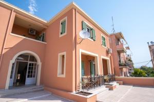Ágios RókkosZoes Luxury Apartment Corfu的粉红色的房子,设有门廊和阳台
