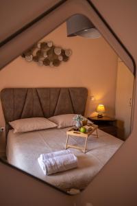 Ágios RókkosZoes Luxury Apartment Corfu的一间卧室配有一张带桌子和镜子的床