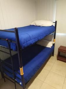 巴伊亚英格莱萨Camping Las Machas的配有蓝色床单和枕头的双层床