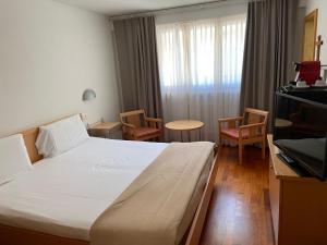 Visperterminen红峰酒店及餐馆的酒店客房带一张床、一张桌子和椅子