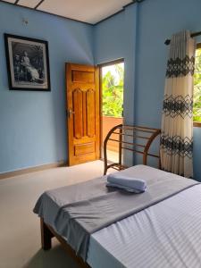 贾夫纳Nalluran illam - 2 bed room的一间卧室配有一张蓝色墙壁和门的床