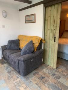 斯旺西Molehill lodge的一张棕色沙发,配有枕头,位于房间里