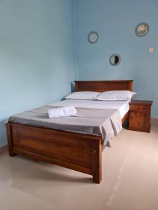 贾夫纳Nalluran illam - 2 bed room的蓝色墙壁的客房内的一张木床