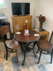 斯旺西Molehill lodge的一张桌子、一瓶葡萄酒和两把椅子