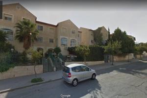 耶路撒冷Best Home Jerusalem Holy Land Close to Everything Israel Gateway 4 families & individual的停在大楼前的小银车