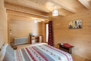 瓦托内切Chalet Gaspard的木制客房内的一间卧室,配有一张床