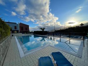 圣乌尔苏拉Tenerife Family Home的大型游泳池设有2把蓝色椅子