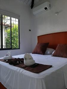 比亚维森西奥Cabañas LLano Lindo Apiay的一间卧室配有一张带白色床单的床和一扇窗户。