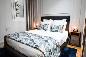 拉梅戈6/4 de Lamego的一间卧室配有一张带蓝色和白色床单及枕头的床。
