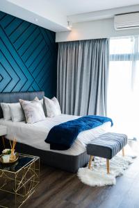 比勒陀利亚703 Menlyn Maine Residences, The Trilogy的一间卧室设有一张蓝色墙壁的大床