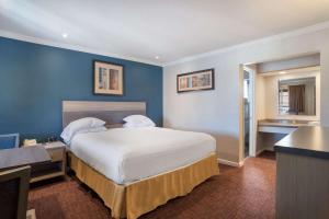 圣拉斐尔SureStay Hotel by Best Western San Rafael的一间卧室设有一张蓝色墙壁的大床