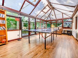 阿尔弗斯顿Eden House的温室设有窗户,配有乒乓球桌