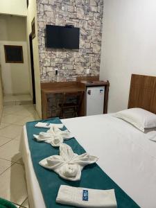 圣托梅-达斯莱特拉斯Pousada Pedra Encantada的酒店客房,配有带毛巾的床