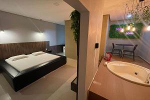 阿拉皮拉卡Lotu's Motel的一间卧室配有一张床、一个浴缸和一个水槽