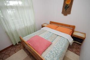 博格莫耶Seaside secluded apartments Cove Smokvina, Hvar - 4036的一间卧室配有带橙色枕头的床和窗户。