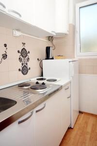 斯拉诺Apartments and rooms with a swimming pool Slano, Dubrovnik - 2179的白色的厨房配有炉灶和水槽