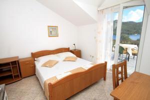 斯拉诺Apartments and rooms with parking space Slano, Dubrovnik - 2159的一间卧室设有一张床和一个阳台