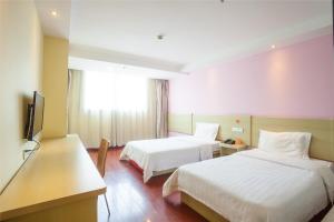 怀柔7天连锁酒店北京怀柔店的酒店客房设有两张床和一台平面电视。