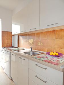 维拉斯奇Apartments with a parking space Vlasici, Pag - 4139的厨房配有水槽和橙色的柜台。