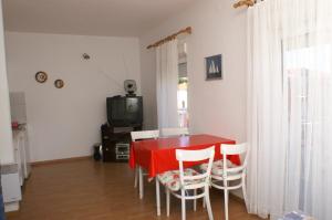 布罗达里卡Apartments with a parking space Brodarica, Sibenik - 4239的一间用餐室,配有红色的桌子和椅子