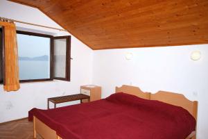 斯拉诺Rooms by the sea Sladjenovici, Dubrovnik - 2161的一间卧室设有红色的床和窗户。