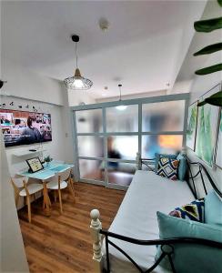 大雅台Ohana at Tagaytay Prime的一间卧室配有一张床,另一间用餐室配有桌子